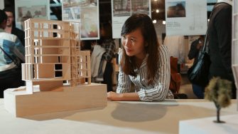 Architecture student examining a building model