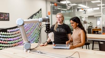 ADA Technician and student working with a collaborative robot.
