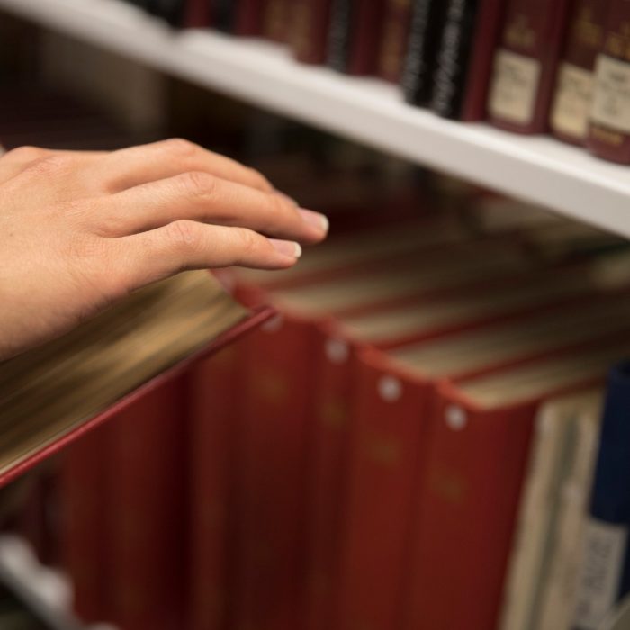 Hand on books in library Hand on books in library