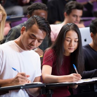 Students with laptops in lecture theatre class