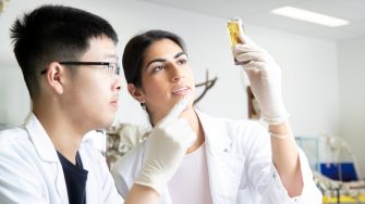 Students in Science Lab with white lab coat doing experiments