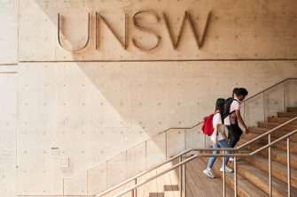 Students walking down L5 stairs in front of UNSW logo
