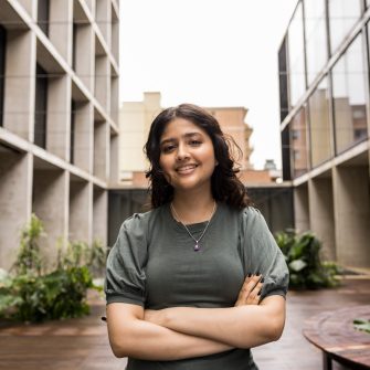 Close up of female student with arms crossed in courtyard at L5