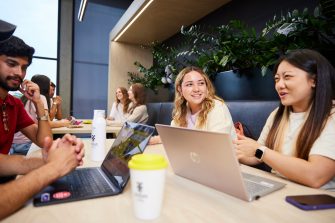 UNSW College Students seated together, laptops open, chatting in common room