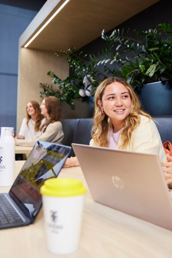 UNSW College Students seated together, laptops open, chatting in common room