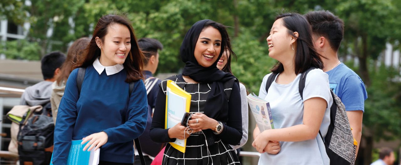 Students walking outside with books