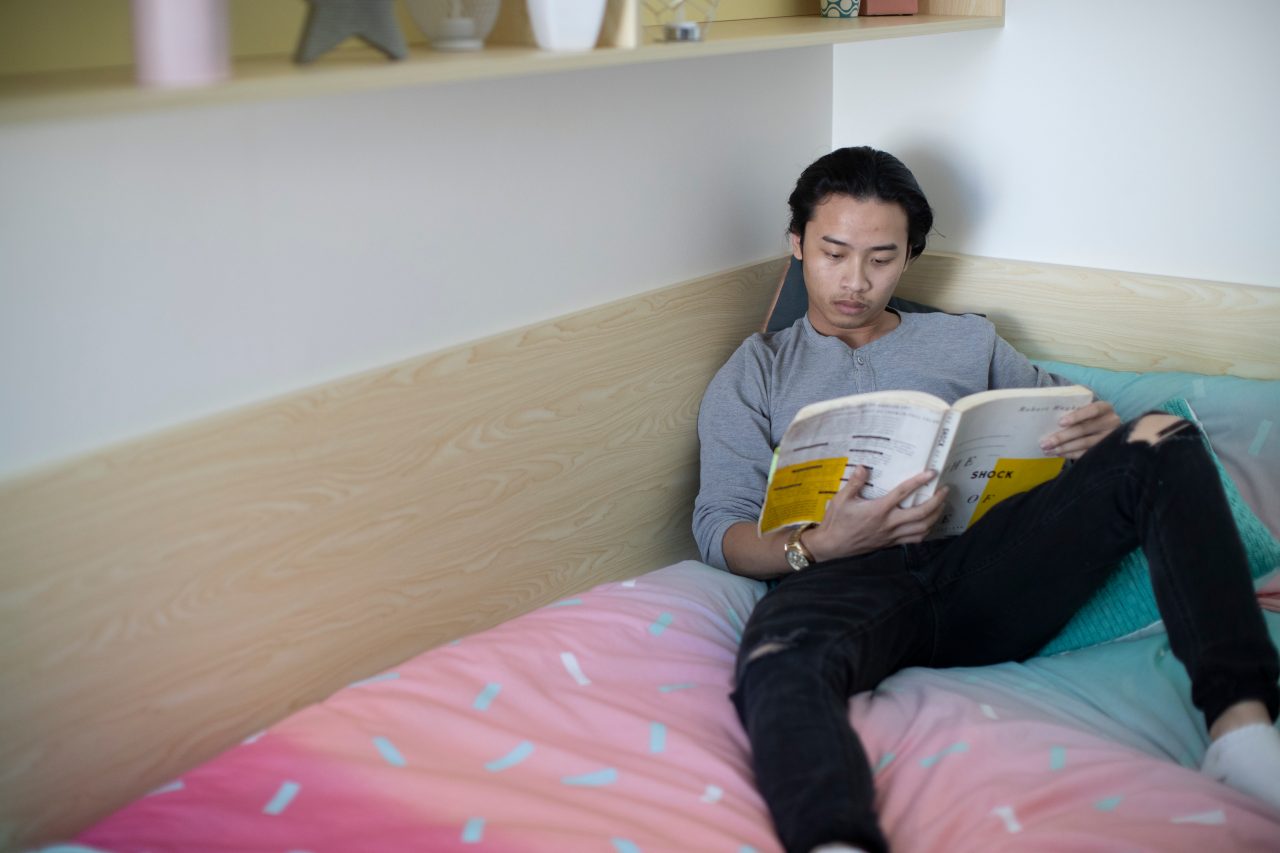 Student reading in bed at student accommodation