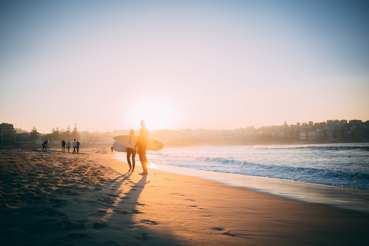 Surfers on Bondi Beach at sunset
