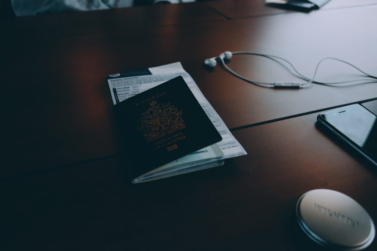 Passport, phone and headphones on a desk