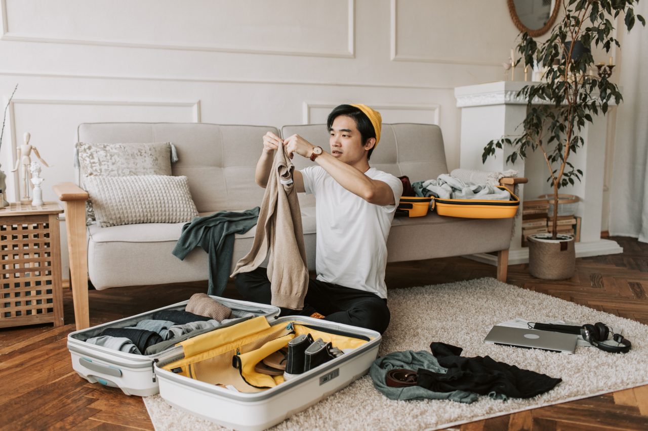 Young man packing a suitcase