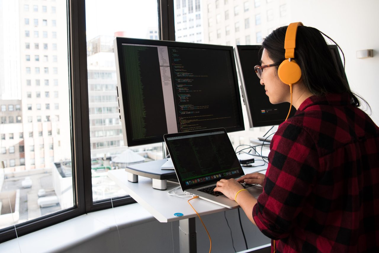 Software developer at computer wearing headphones