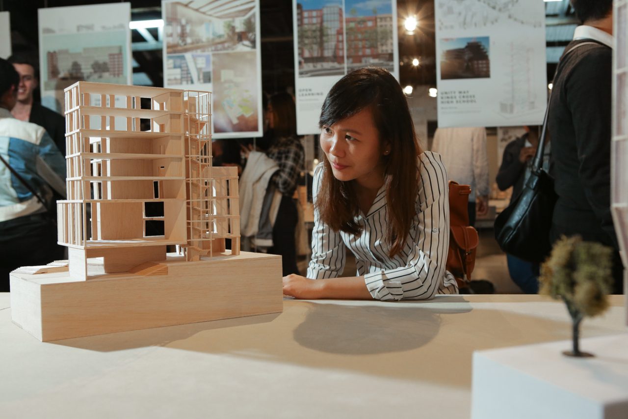 Student looking at a wooden model of a building